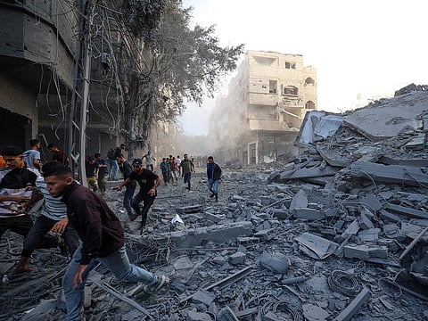 People run for cover following an Israeli strike that targeted a building in the Bureij camp for Palestinian refugees in the central Gaza Strip.
