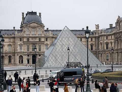 Police stand near the Louvre Museum pyramid following a robbery.
