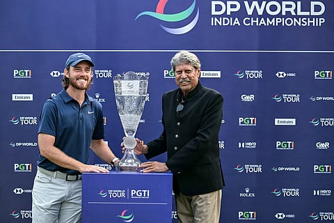 England's Tommy Fleetwood (L) poses with the trophy along with Kapil Dev, President of the Professional Golf Tour of India (PGTI), after winning the DP World India Championship 2025 golf tournament at the Delhi Golf Club in New Delhi on October 19, 2025.