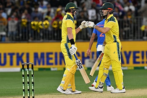 Australia's Matt Renshaw (L) and Mitchell Marsh exchange bump gloves during the first one-day international cricket match between Australia and India in Perth on October 19, 2025.