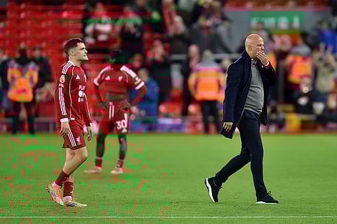 Liverpool's Dutch manager Arne Slot and German midfielder Florian Wirtz react following the English Premier League football match against Manchester United at Anfield in Liverpool, north west England on October 19, 2025.