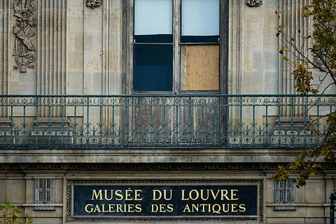 The window of the Louvre Museum is seen with the glasses covered after the thieves broke them to get in and steal priceless jewels.