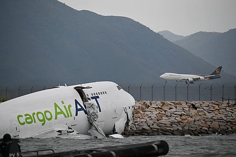 An ACT Airlines Boeing 747-400 cargo aircraft (L), wet leased by Emirates SkyCargo, is seen in the water after veering off the runway during landing on the north runway of Hong Kong's international airport on October 20, 2025, and skidded into the sea, killing two.