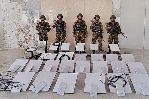 In this image provided by the Myanmar military on Oct. 19, 2025, soldiers stand next to Starlink machines as they seize KK Park online scam center in Myawaddy township, Karen State, Myanmar.
