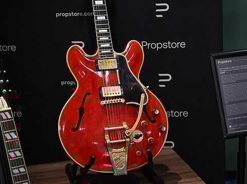 Noel Gallagher's 1960's Cherry Red Gibson ES-355 guitar, damaged by Liam Gallagher the night Oasis broke up and estimated to sell for between 250,000 and 500,000 GBP (288,000-576,000 Euro, 334,000-669,000 USD) is pictured on display during a Propstore auction preview in London on October 21, 2025.