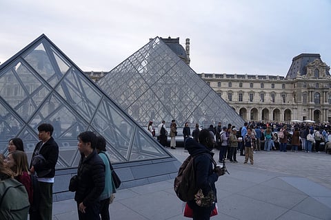 Visitors queue to enter the Louvre museum three days after historic jewels were stolen in a daring daylight heist, Wednesday, Oct. 22, 2025 in Paris.