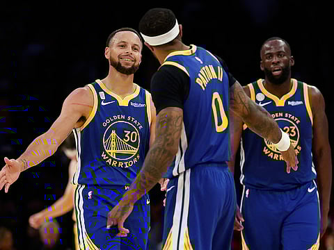 Stephen Curry #30 and Gary Payton II #0 of the Golden State Warriors celebrate in the final minute of the fourth quarter of the game against the Los Angeles Lakers at Crypto.com Arena.