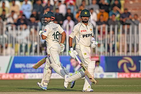 Pakistan's Mohammad Rizwan (L) and Babar Azam run between the wickets during the third day of the second Test cricket match between Pakistan and South Africa at the Rawalpindi Cricket Stadium in Rawalpindi on October 22, 2025.