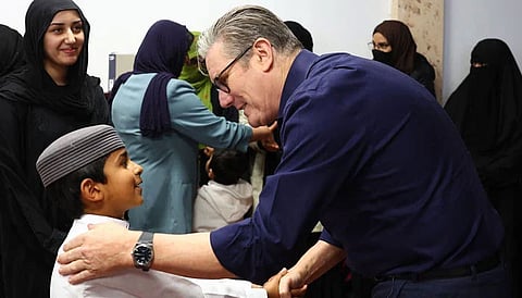 UK Prime Minister Keir Starmer shakes hand with a child during his visit to Peacehaven Mosque in East Sussex.