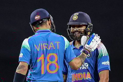 India's Rohit Sharma (R) celebrates with his teammate Virat Kohli after scoring a century (100 runs) during the third one-day international (ODI) men's cricket match between Australia and India at the Sydney Cricket Ground in Sydney on October 25, 2025.