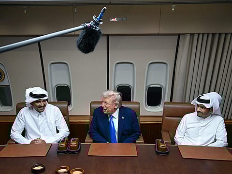 US President Donald Trump meets Qatar’s Emir Sheikh Tamim bin Hamad Al Thani (L) and Prime Minister and Foreign Minister Sheikh Mohammed bin Abdulrahman bin Jassim Al Thani (R) aboard Air Force One in Doha on October 25, 2025, as he makes a refuelling stop on his way to Malaysia for the ASEAN summit.