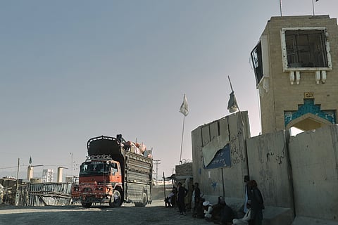 People wait near the closed gate at the Spin Boldak border crossing with Pakistan, after the border was shut for nearly two weeks following clashes between Afghan and Pakistani forces, in Kandahar province, Afghanistan on October 23, 2025.