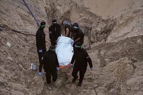 FILE - Hamas militants carry a white bag believed to contain a body, after retrieving it from a tunnel during a search for the remains of hostages in Hamad City, Khan Younis, in southern Gaza, Tuesday, Oct. 28, 2025. (AP Photo/Jehad Alshrafi, File)