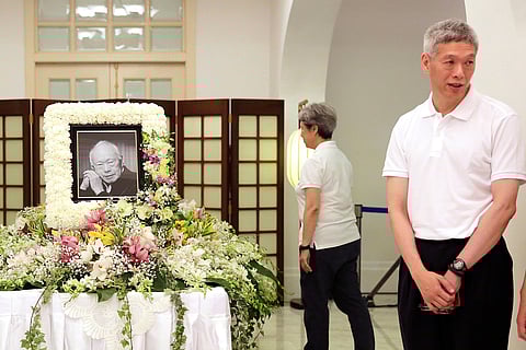 In this March 24, 2015, file photo, Prime Minister Lee Hsien Loong's brother, Lee Hsien Yang, right, receives friends and family members paying their respects to the late Lee Kuan Yew during a private family wake at the Istana or Presidential Palace in Singapore.