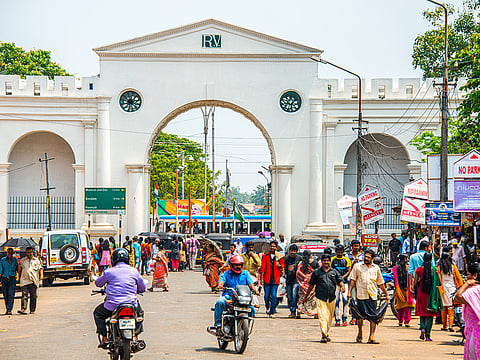 A bustling street scene at the entrance of a colonial-era structure in Thiruvananthapuram, Kerala, India. Kerala has become the first state in India to eradicate extreme poverty.