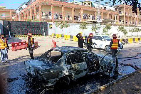Firefighters douse a car at the suicide blast site in Islamabad on November 11, 2025.