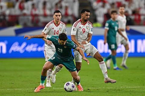 Iraqi's Merchas Ghazi (centre) is challenged by Harib Abdalla (right) and Nicolas Gimenez of the UAE during the 2026 World Cup play off first leg match in Abu Dhabi.