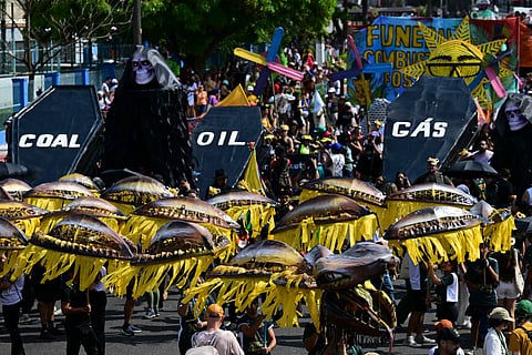 Activists perform the death of fossil fuels at the so-called "Great People's March" in the sidelines of the COP30 UN Climate Change Conference in Belem, Para State, Brazil. File photo taken on November 15, 2025.