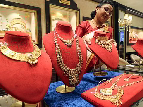 A saleswoman with a gold necklace at a jewellery shop (Photo/ANI)