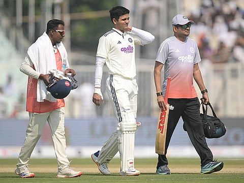 India's captain Shubman Gill (C) walks back to the pavilion after his injury during the second day of the first Test match against South Africa at the Eden Gardens in Kolkata on November 15, 2025.