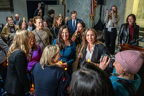 US congresswoman Teresa Leger Fernandez (C), Democrat of New Mexico, celebrates with victims of convicted sex offender Jeffrey Epstein, after announcing to attendees of a candlelight vigil, that the US Senate passed the "Epstein Files Transparency Act" in Washington, DC on November 18, 2025.