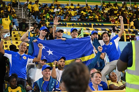 Curacao supporters cheer during the World Cup qualifier football match between Jamaica and Curacao at the National Stadium in Kingston, Jamaica on November 18, 2025.