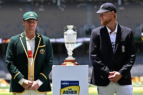 Australia's captain Steve Smith (L) and England's captain Ben Stokes stands next to the Waterford Crystal Ashes trophy at Perth Stadium in Perth on November 20, 2025, ahead of the first Ashes cricket Test match.