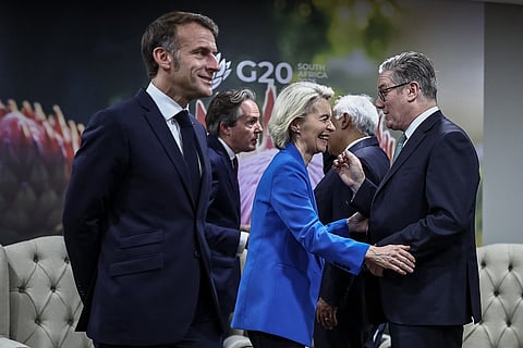 Britain's Prime Minister Keir Starmer (R) speaks to European Commission President Ursula Von der Leyen (C) as France’s President Emmanuel Macron (L) walks past ahead of the G7++ meeting on the sidelines of a G20 Leaders' Summit plenary session at the Nasrec Expo Centre in Johannesburg on November 22, 2025.
