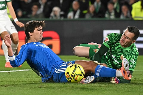 Real Madrid's Spanish forward #16 Gonzalo Garcia and Elche's Spanish goalkeeper #13 Inaki Pena fight for the ball during the Spanish league football match between Elche CF and Real Madrid CF at Martinez Valero Stadium in Elche on November 23, 2025.