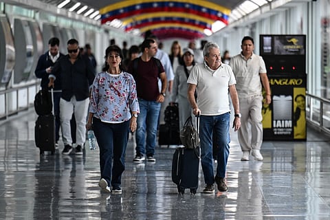 Passengers walk after arriving at Maiquetia Simon Bolivar International Airport in Caracas on November 24, 2025.