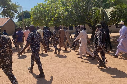 Police and government officials walk past St. Mary's Catholic Primary and Secondary School where gunmen on Friday abducted children and staff in Papiri community, Nigeria. File photo taken on Tuesday, Nov.25, 2025.