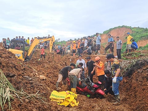 Indonesian National Search and Rescue Agency (BASARNAS), rescuers remove a scooter buried in the mud as they search for victims at a village hit by a landslide in Batu Goading, North Sumatra, Indonesia