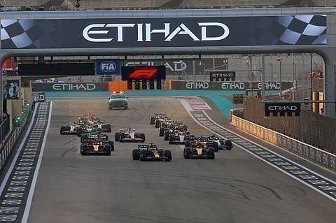 Max Verstappen of Red Bull and Lando Norris of McLaren leads the pack at start of Formula 1 Etihad Airways Abu Dhabi Grand Prix 2025.