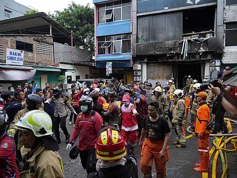 Rescuers carry out the body of a victim from the site of a fire in Jakarta, Indonesia, Tuesday, Dec. 9, 2025.