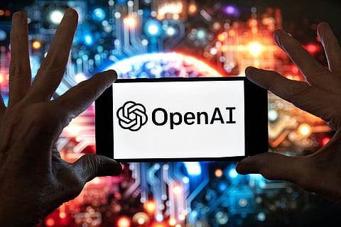 The OpenAI logo is seen displayed on a cell phone in front of an image on a computer screen generated by ChatGPT's Dall-E text-to-image model, Friday, Dec. 8, 2023, in Boston.