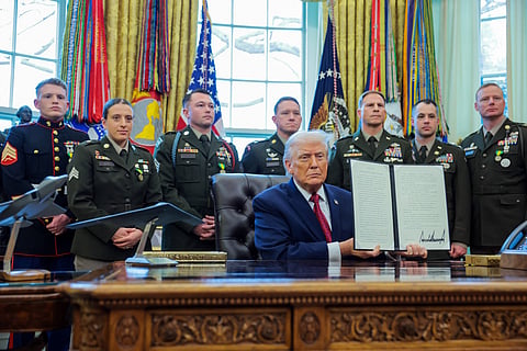 President Donald Trump poses with a recently signed executive order classifying fentanyl as a "weapon of mass destruction," during a ceremony for the presentation of the Mexican Border Defense Medal in the Oval Office of the White House on December 15, 2025 in Washington, DC. During the ceremony, Trump recognized the first 13 service members to receive the recently established Mexican Border Defense Medal (MBDM), which recognizes service members supporting Customs and Border Protection on the U.S.-Mexico border.
