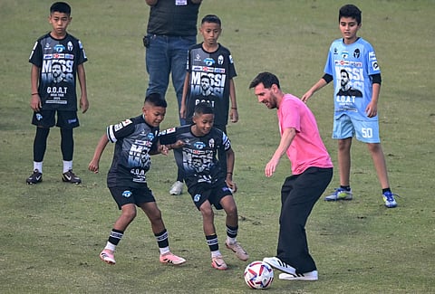 Argentina's footballer Lionel Messi plays football with children during his GOAT Tour at the Arun Jaitley Stadium in New Delhi on December 15, 2025.