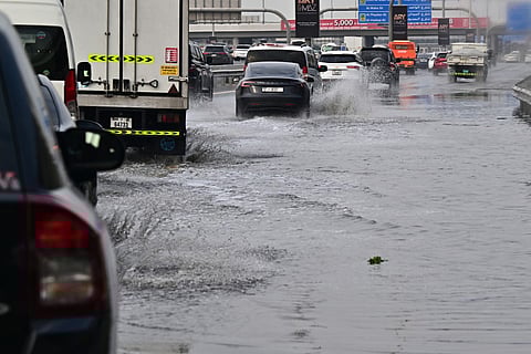 Vehicles drive on a flooded road during heavy rain in Dubai on Thursday, December 18, 2025.