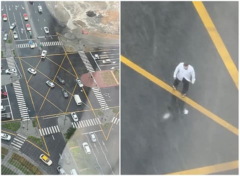 Streets flood across Dubai as a man stands in the downpour, helping motorists safely navigate