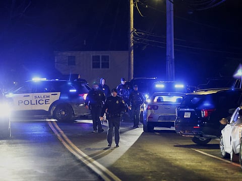 Law enforcement officers search the area for the Brown University shooting suspect, Thursday, Dec. 18, 2025, in Salem