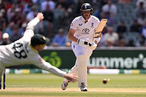 England batsman Jamie Smith (R) drives a ball past Australian fieldsman Josh Inglis on the final day of the third Ashes cricket Test match between Australia and England at the Adelaide Oval in Adelaide on December 21, 2025.