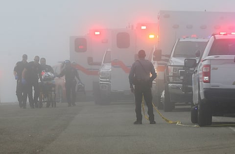 Emergency personnel rush a victim of a small plane crash to an awaiting ambulance, Monday, Dec. 22, 2025, near the Galveston causeway, near Galveston, Texas. (Jennifer Reynolds/The Galveston County Daily News via AP)