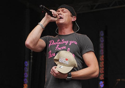 Vocalist Brad Arnold of 3 Doors Down holds a fan's "I Love Jesus" hat while the band performs on "FOX and Friends" outside of FOX Studios on July 29, 2011 in New York City.