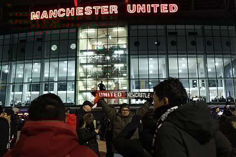 Fans arrive at the ground ahead of the English Premier League football match between Manchester United and Newcastle United at Old Trafford in Manchester, north west England, on December 26, 2025.