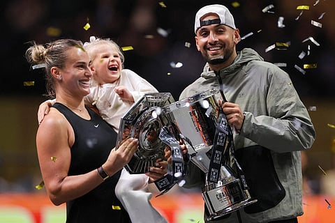 Belarus' Aryna Sabalenka, her goddaughter Nicole, and Australia's Nick Kyrgios celebrate with trophies at the end of the Battle of the Sexes exhibition tennis match in Dubai on December 28, 2025.