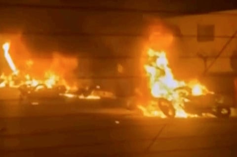 This frame grab from a video released by Iran state TV shows vehicles burning amid night of mass protests in Tehran.