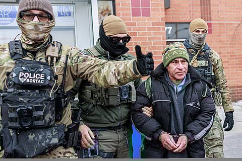 Masked US Border Patrol agents escort a man after detaining him near a residential area in Minneapolis, Minnesota, on January 11, 2026. Photo for illustrative purposes only.
