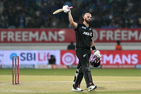New Zealand's Daryl Mitchell celebrates after scoring a century (100 runs) during the second one-day international (ODI) cricket match between India and New Zealand at Niranjan Shah Stadium in Rajkot on January 14, 2026.
