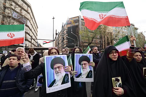 Iranian women hold portraits of Iran’s Supreme Leader Ayatollah Ali Khamenei during the funerals of security forces personnel killed in recent protests in Tehran on January 14, 2026.