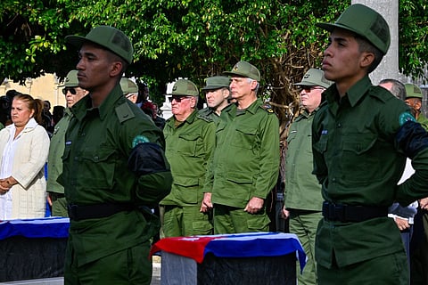 Cuba's President Miguel Diaz-Canel (C) attends the funeral of the 32 Cuban soldiers killed during the US incursion in Venezuela at Colon cemetery in Havana on January 16, 2026.